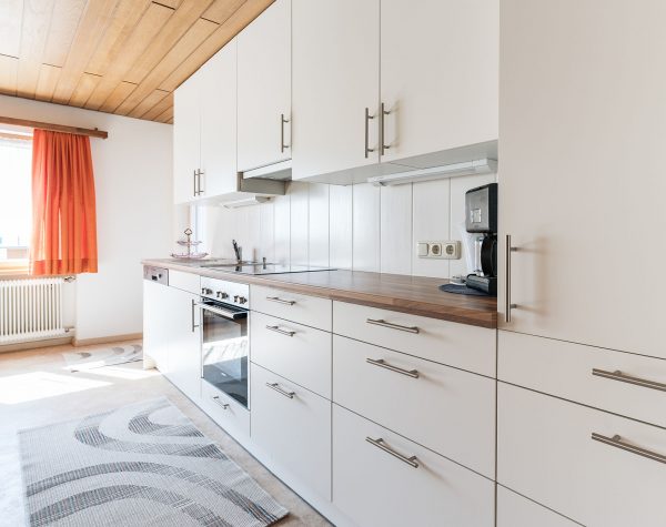 Helle weiße Küchenzeile mit Spülmaschine, Herd und Backofen